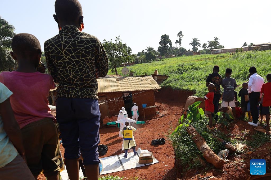 Medical workers in protective suits are disinfected before the burial of an Ebola victim in Mongbwalu, Ituri province, eastern Democratic Republic of the Congo (DRC), May 24, 2026. World Health Organization (WHO) Director-General Tedros Adhanom Ghebreyesus said on Sunday that as the Democratic Republic of the Congo (DRC) scales up surveillance in its Ebola response, more than 900 suspected cases have been identified so far, including 101 confirmed cases. (Photo: Xinhua)