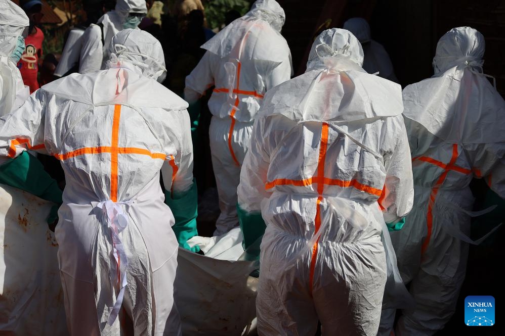 Medical workers in protective suits transfer the body of an Ebola victim in Mongbwalu, Ituri province, eastern Democratic Republic of the Congo (DRC), May 24, 2026. World Health Organization (WHO) Director-General Tedros Adhanom Ghebreyesus said on Sunday that as the Democratic Republic of the Congo (DRC) scales up surveillance in its Ebola response, more than 900 suspected cases have been identified so far, including 101 confirmed cases. (Photo: Xinhua)