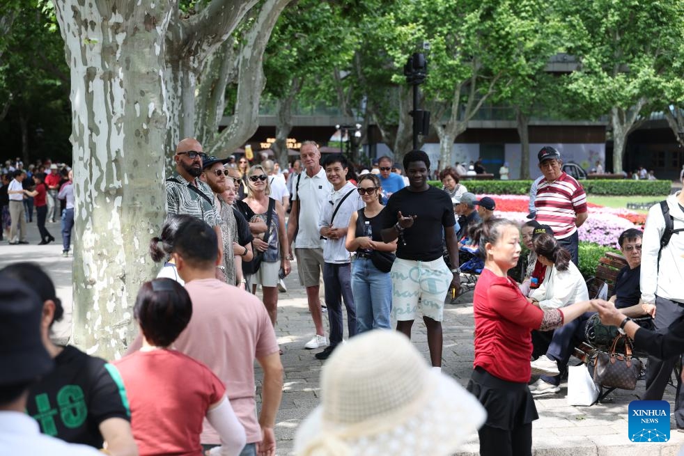 Liu Lichao leads his clients to visit Fuxing Park in east China's Shanghai, May 16, 2026. (Photo: Xinhua)