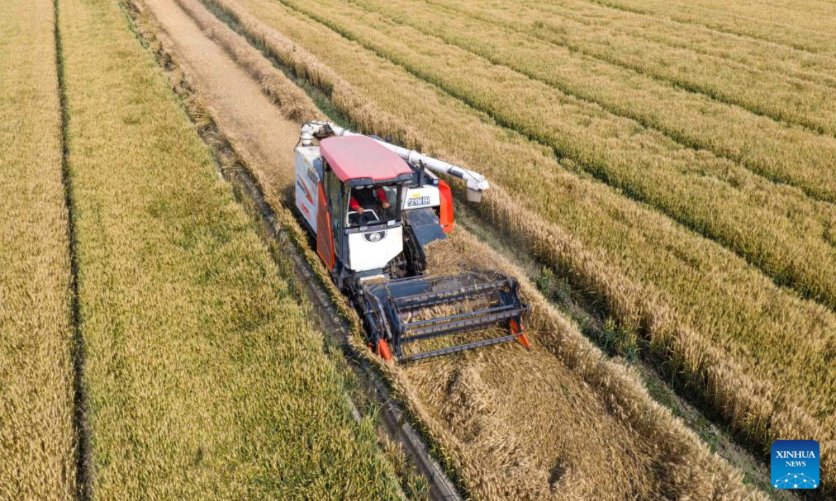 An aerial drone photo taken on May 28, 2026 shows an agricultural machine harvesting wheat at Huguan Village in Xinghua City, east China's Jiangsu Province. (Photo by Zhou Shegen/Xinhua)