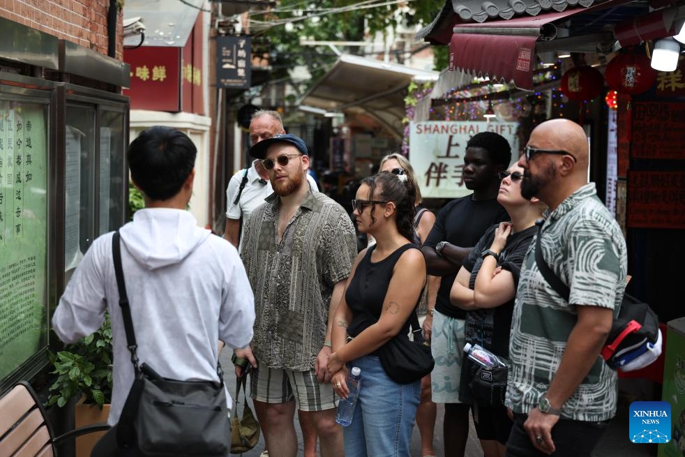 Liu Lichao (1st L) leads his clients to visit Tianzifang art area in east China's Shanghai, May 16, 2026. (Photo: Xinhua)