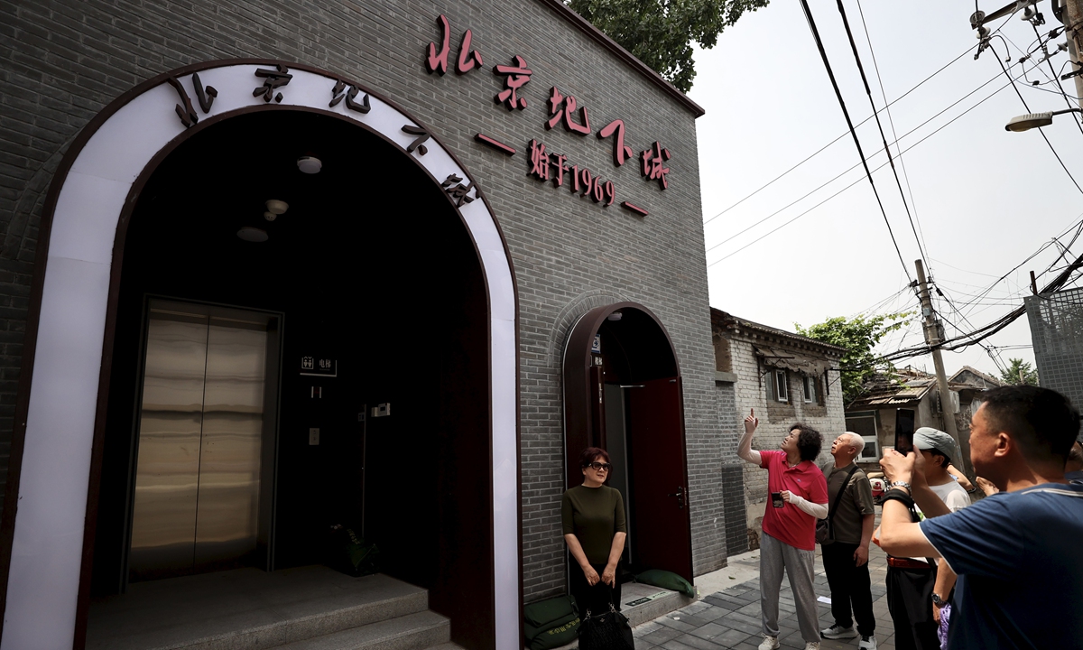 A visitor poses for photos in front of the entrance of the Beijing Underground City on April 19, 2026. Photos: VCG