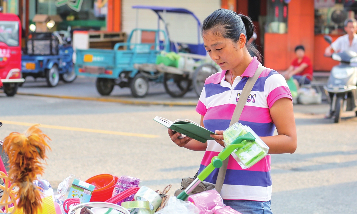 Chen Hui reads a book at the Liangnong market in Yuyao, East China's Zhejiang Province. Photo: Courtesy of local photographer Xu Xuedong