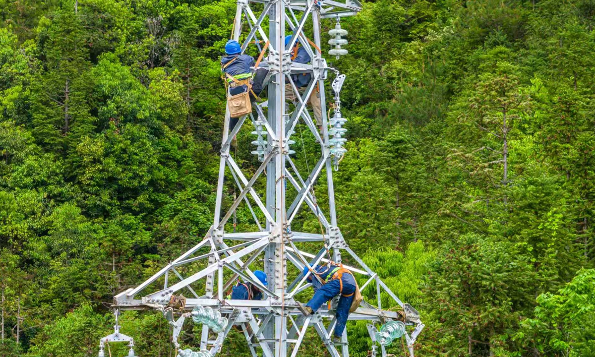 Power grid workers carry out high-altitude tower assembly and installation work to help ensure power supply during the summer peak, in Xiuning county, Huangshan, East China's Anhui Province, on April 24, 2026. Photo: VCG