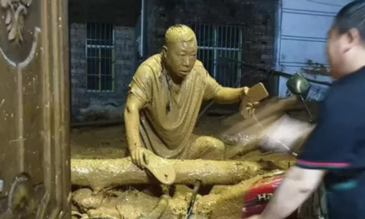 Photo: Tian Ruliang covered in mud during the mudslide