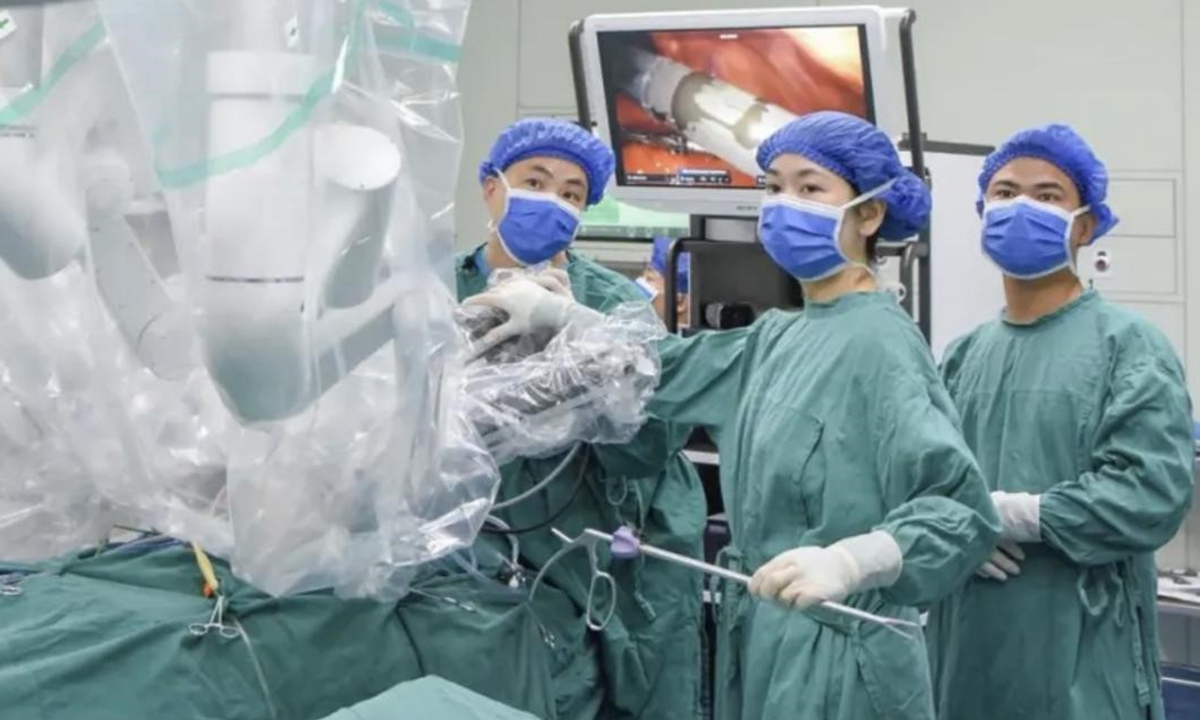 The surgical team performs the operation with the assistance of a remote-controlled surgical robot on May 22, 2026. Photo: Jimu News