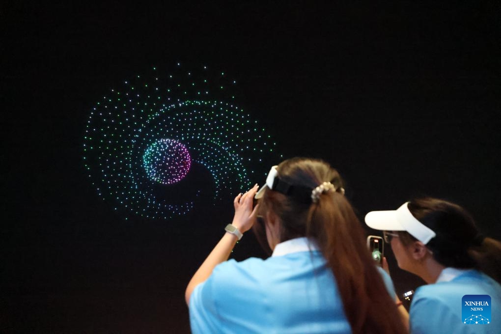 People enjoy a drone show in Tianjin, north China, on May 28, 2026. The robot carnival, a session of the World Intelligence Expo 2026, was held at the Tianjin cultural center on Thursday. A series of events, including a robot exhibition, a robotics competition and a robot stage show, give the audience a glimpse of technology and smart living. (Xinhua/Sun Fanyue)