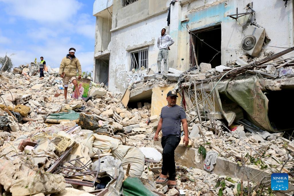 Local people inspect the debris of a building destroyed by Israeli airstrikes in Borj El Chmali, southern Lebanon, on May 27, 2026. At least 17 people were killed and dozens wounded in Israeli strikes across southern and eastern Lebanon, Lebanese media and health authorities reported Thursday. (Photo by Ali Hashisho/Xinhua)