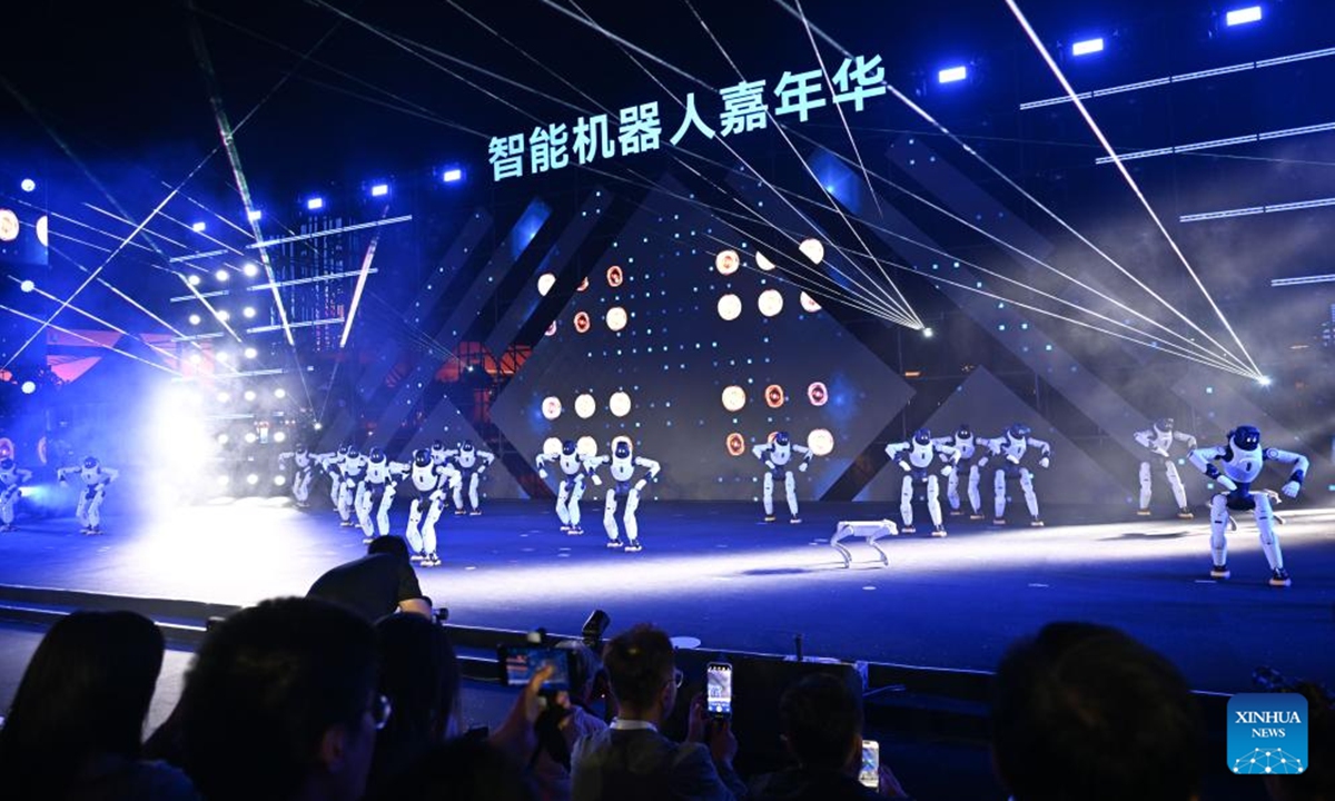 People enjoy a performance staged by robots in Tianjin, north China, on May 28, 2026. The robot carnival, a session of the World Intelligence Expo 2026, was held at the Tianjin cultural center on Thursday. A series of events, including a robot exhibition, a robotics competition and a robot stage show, give the audience a glimpse of technology and smart living. (Xinhua/Sun Fanyue)