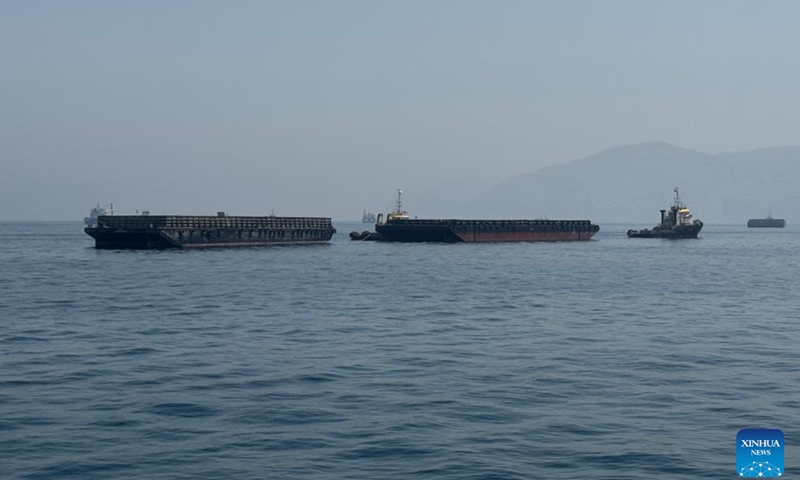 This photo taken with a mobile phone shows merchant vessels stranded in the waters of the Strait of Hormuz, near Khasab, a small town in northern Oman, May 29, 2026. (Photo: Xinhua)
