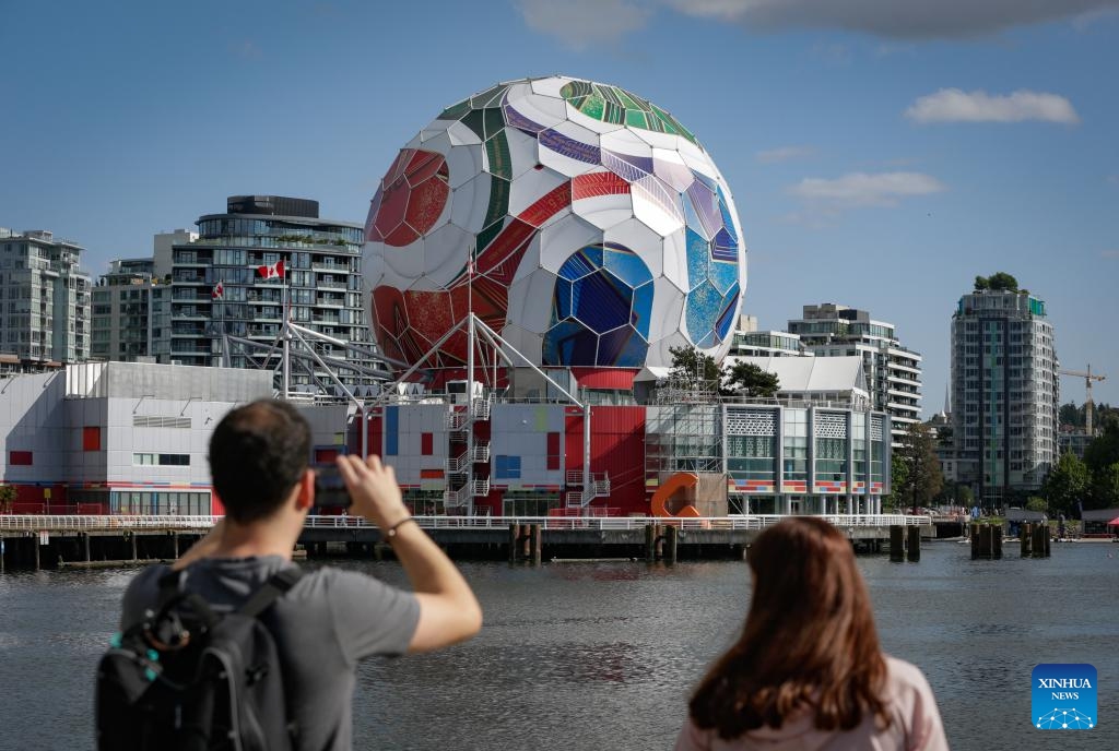 A man takes photos of the dome of Science World as it is being transformed into a giant official match ball of the FIFA World Cup 2026 ahead of the tournament in Vancouver, British Columbia, Canada, on May 29, 2026. (Photo: Xinhua)