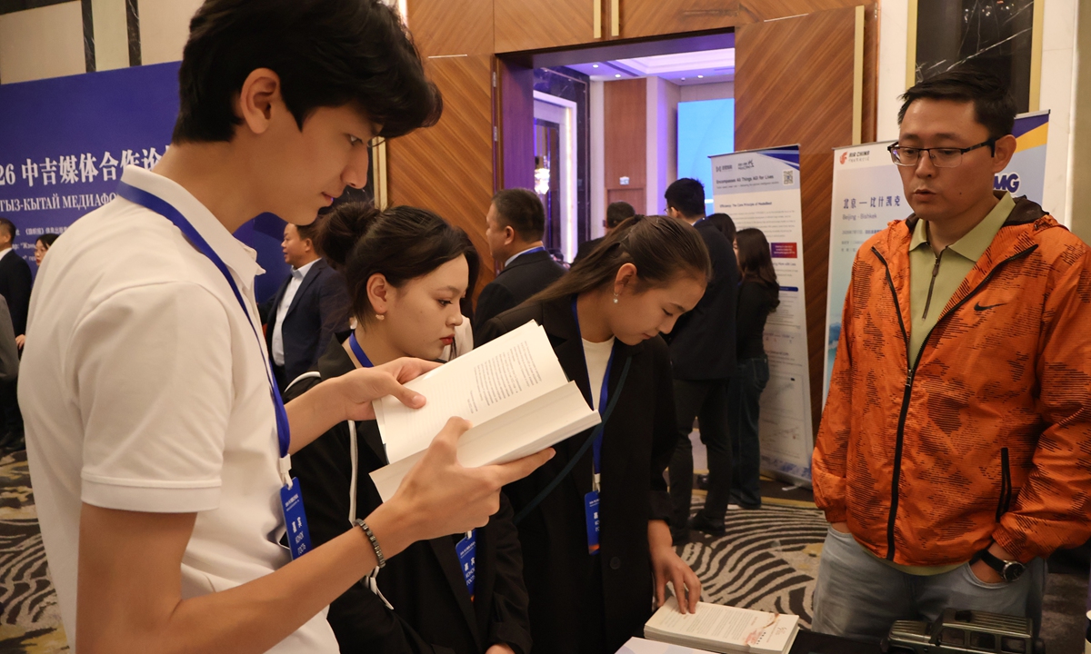 A guest reads the book Xi Jinping: The Governance of China at the venue of the 