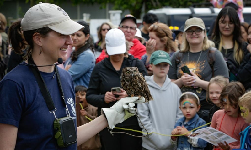 A staff member introduces a rehabilitated owl during an open house event at the Orphaned Wildlife Rehabilitation Society in Delta, British Columbia, Canada, on May 30, 2026. The event held on Saturday offered the public an opportunity to learn about the rehabilitation, care, and conservation of injured and orphaned birds of prey. (Photo by Liang Sen/Xinhua)