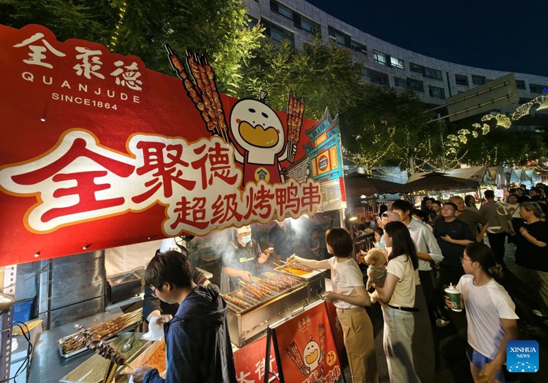People purchase Peking Duck skewers during a tea fair in the Financial Street community of Beijing, capital of China, May 30, 2026. The event is held from May 28 to 31 in Xicheng District of Beijing. (Xinhua/Xing Guangli)