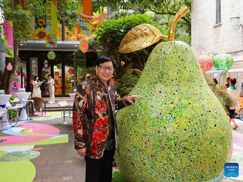 Copper carving master Zhu Bingren shows up during his pop-up art show titled Zhu Bingren's fruit party in Shanghai, east China, May 30, 2026. The show will last until June 29. (Xinhua/Liu Ying)