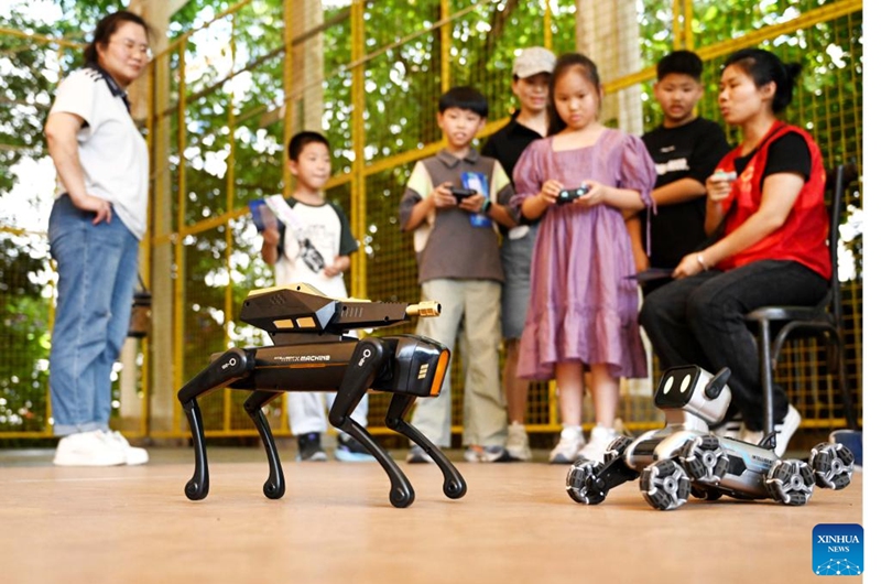 Children interact with robot dogs at the science and technology museum of a youth palace in Wuyi County of Jinhua City, east China's Zhejiang Province, May 31, 2026. Various events were held across the country on Sunday to celebrate the upcoming International Children's Day. (Photo by Zhang Jiancheng/Xinhua)