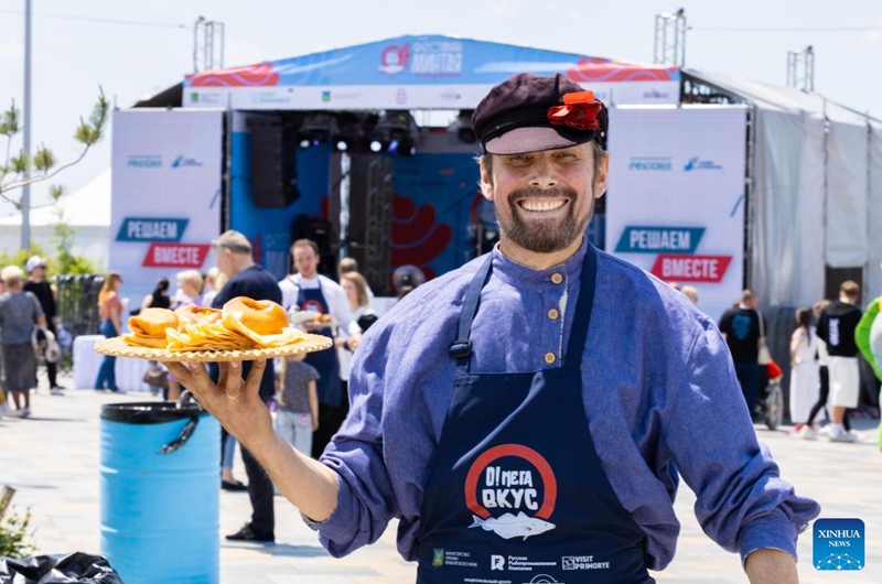 A chef shows a dish made with pollack during a pollack festival in Vladivostok, Russia, on May 30, 2026. Pollack is a popular seafood ingredient among the locals here. (Photo by Andrey Matveenko/Xinhua)