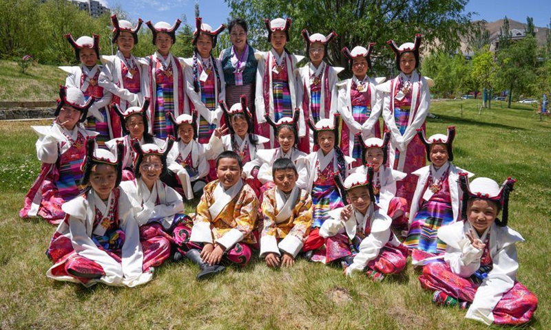 Nyima Tsamjo poses for a group photo with her students participating in a children's art gala in Lhasa, southwest China's Xizang Autonomous Region, May 30, 2026. (Xinhua/Tenzing Nima Qadhup)