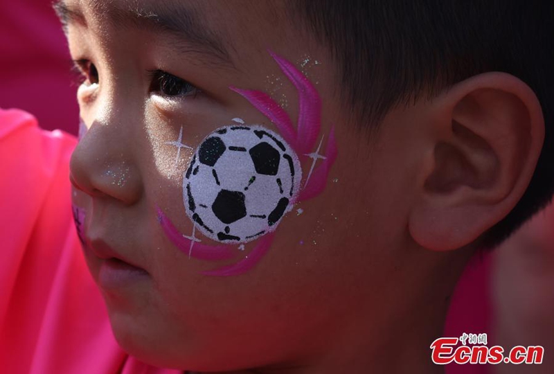 A young football fan with a soccer-themed face painting watches the game during the Jiangsu City Football League in Zhenjiang City, east China's Jiangsu Province, May 30, 2026. Photo: China News Service 