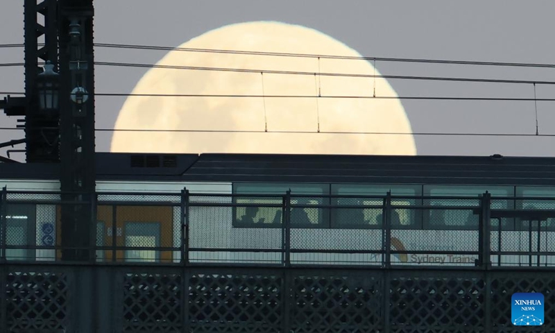 The full moon, known as the Blue Moon, is seen behind a running train on the Sydney Harbour Bridge in Sydney, Australia, on May 31, 2026. (Xinhua/Gong Bing)
