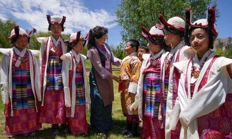 Nyima Tsamjo dresses her students participating in a children's art gala in Lhasa, southwest China's Xizang Autonomous Region, May 30, 2026. (Xinhua/Tenzing Nima Qadhup)