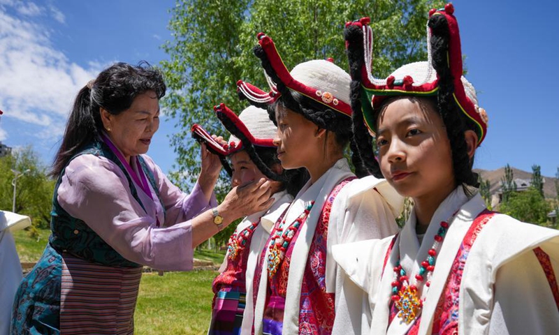 Nyima Tsamjo dresses her students participating in a children's art gala in Lhasa, southwest China's Xizang Autonomous Region, May 30, 2026. (Xinhua/Tenzing Nima Qadhup)