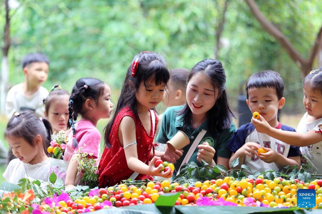 A teacher and children gather around a table at a nature education base of a kindergarten in Leshan, southwest China's Sichuan Province, June 1, 2026. International Children's Day was celebrated across China on Monday. (Photo: Xinhua)