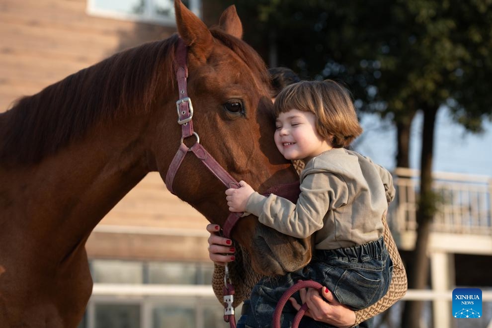 Maya interacts with her horse Lector at the Yangtze River Delta International Equestrian Center in Dongting Town of Guangde City, east China's Anhui Province, Jan. 16, 2026. The family settled in Dongting Town, home to the Yangtze River Delta International Equestrian Center. Maya's mother, Aleksandra Timofeeva, better known as Sasha, is an equestrian from Russia and her father, Vasil Ivanou, a coach from Belarus. (Photo: Xinhua)