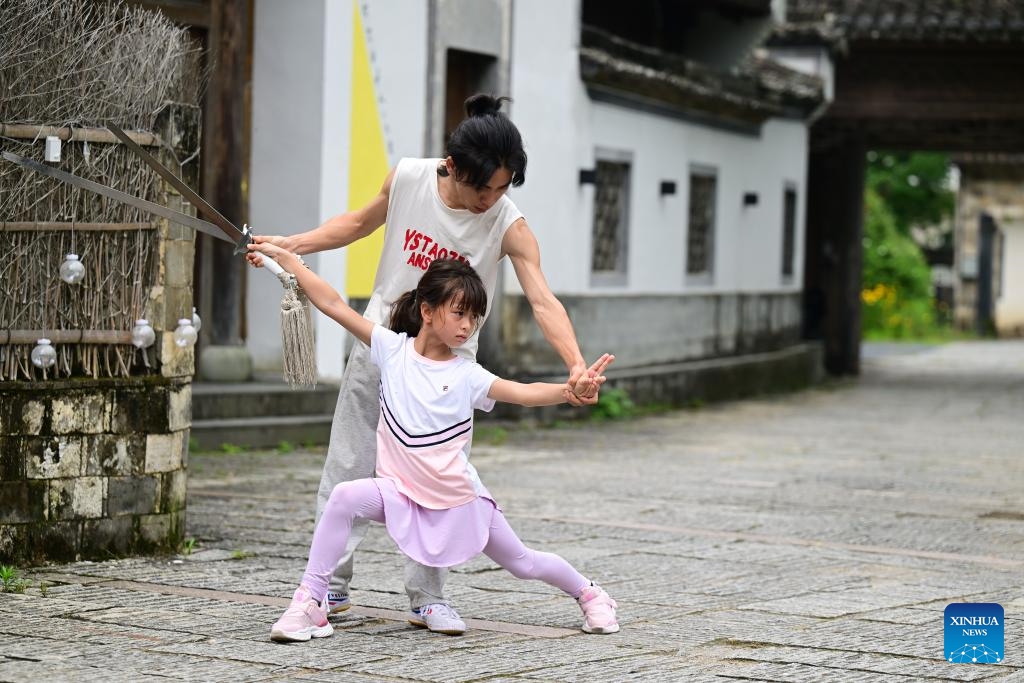 Alina (front) practices Chinese martial arts under her teacher's guidance in Yixian County, east China's Anhui Province, on May 30, 2026. When some mayors and city representatives from around the world visited Yixian County for an international event, 8-year-old Alina, who received these foreign guests with her parents, quickly caught people's attention. Fluent in both Chinese and English, she welcomed the guests with a lively performance of Chinese martial arts and Huangmei Opera, earning warm applause. (Photo: Xinhua)