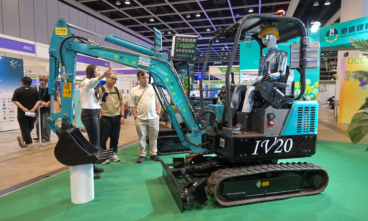 Visitors look at an electric remote-controlled excavator on display at an occupational safety and health innovation and technology expo in the Hong Kong Special Administrative Region on June 2, 2026. The two-day expo brings together more than 100 organizations to showcase innovative solutions, products and technologies aimed at improving workplace safety and health. Photo: VCG