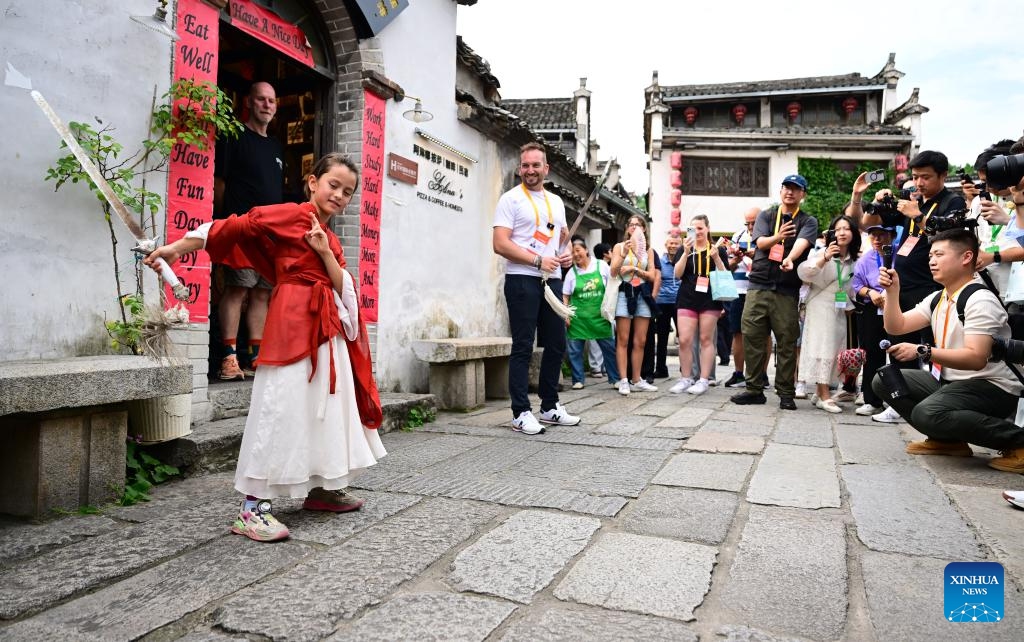 Alina (L, front) performs Chinese martial arts in Yixian County, east China's Anhui Province, on May 29, 2026. When some mayors and city representatives from around the world visited Yixian County for an international event, 8-year-old Alina, who received these foreign guests with her parents, quickly caught people's attention. Fluent in both Chinese and English, she welcomed the guests with a lively performance of Chinese martial arts and Huangmei Opera, earning warm applause. (Photo: Xinhua)