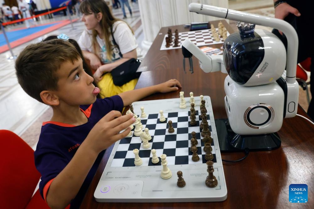 A child plays chess with a robot during an open door event marking International Children's Day at Romania's Parliament Palace in Bucharest, Romania, June 1, 2026. (Photo: Xinhua)
