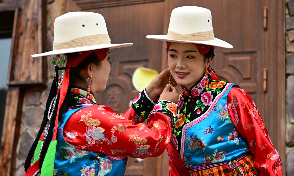 A resident from the Gannan Tibetan Autonomous Prefecture, Northwest China's Gansu Province, helps another resident to don an earring accessory of traditional Tibetan clothing on June 3, 2026. The clothing was inscribed in 2010 as part of the third batch of the provincial-level intangible cultural heritage of Gansu. Photo: VCG