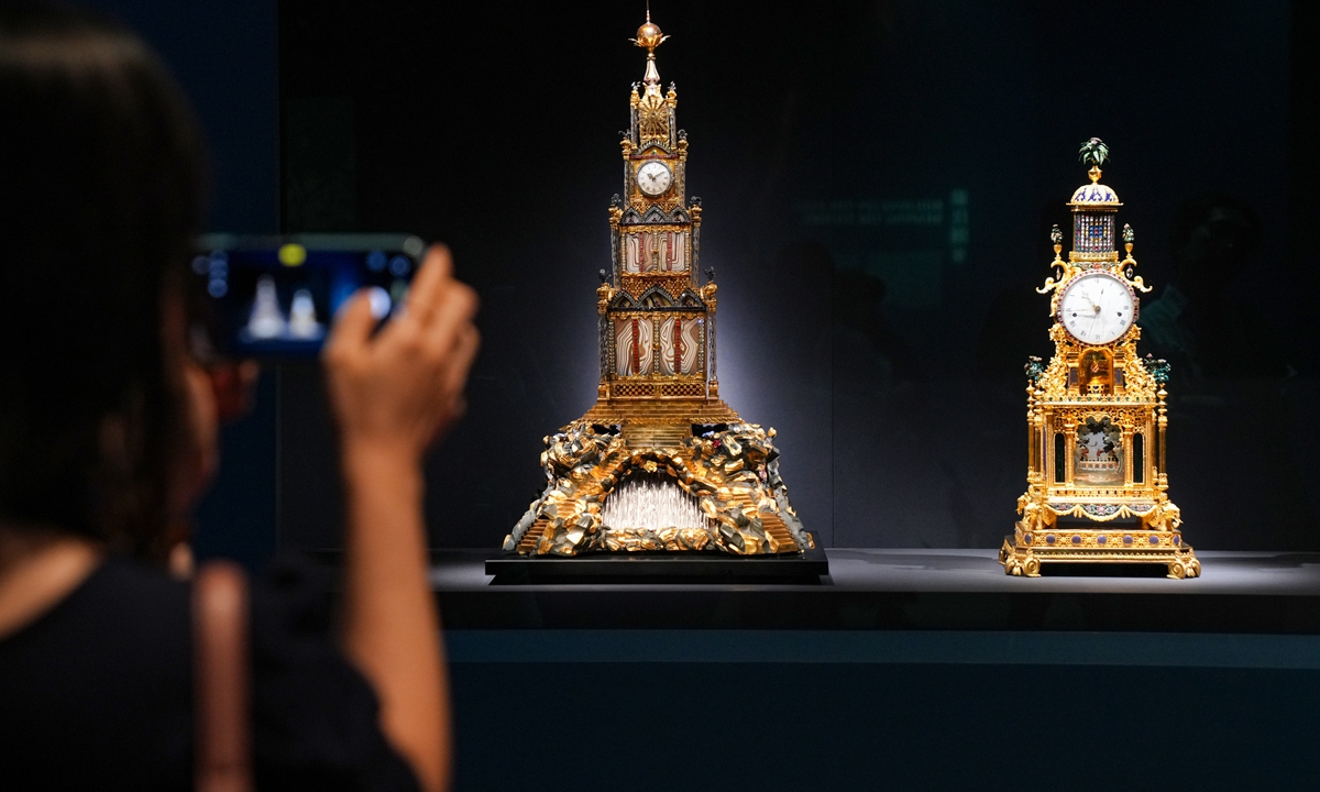 A visitor takes photos of two 18th-century musical table clocks on display at the HKPM. Photo: VCG