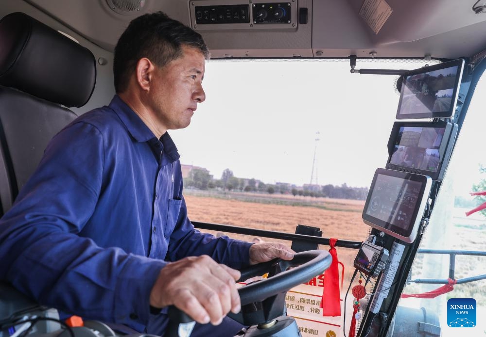 A worker operates a harvester at a smart farm in Zhengwu Town of Fuyang City, east China's Anhui Province, June 3, 2026. The wheat harvest season recently started in various places across Anhui. At a smart farm in Fuyang City, a range of smart devices have been deployed to assist in crop monitoring and harvesting operations. (Photo: Xinhua)