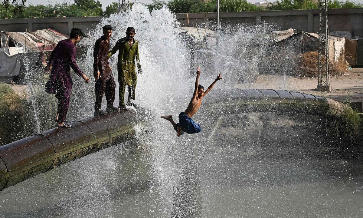 Youth cool off on a leaking water pipeline on a hot summer day in Pakistan's Hyderabad city on June 4, 2026. Pakistan Meteorological Department has forecast below-normal rainfall and above-normal temperatures in most parts of the country in this summer. Photo: VCG 
