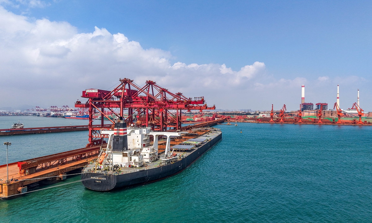A cargo ship unloads imported iron ore at a terminal at Qingdao Port in East China's Shandong Province on Thursday. From January to April, China imported a total of 418.587 million tons of iron ore and its concentrates, a year-on-year increase of 8.0 percent, industry data showed. Photo: VCG