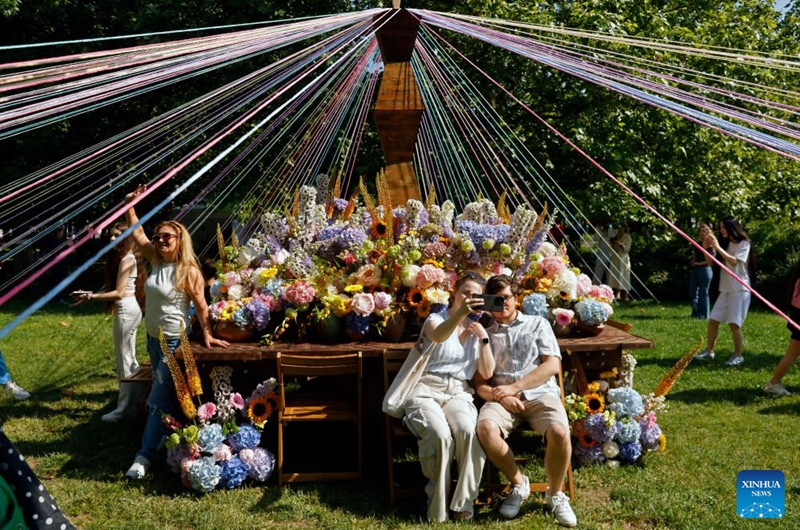 Visitors take pictures during the opening day of the 4th edition of West Side Flower Fest in Bucharest, Romania, on June 5, 2026. (Photo by Cristian Cristel/Xinhua)