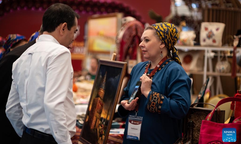 An exhibitor (R) talks with a customer at the Turkmen Textile Expo 2026 in Ashgabat, Turkmenistan, June 5, 2026. (Photo by Cui Jiaxin/Xinhua)