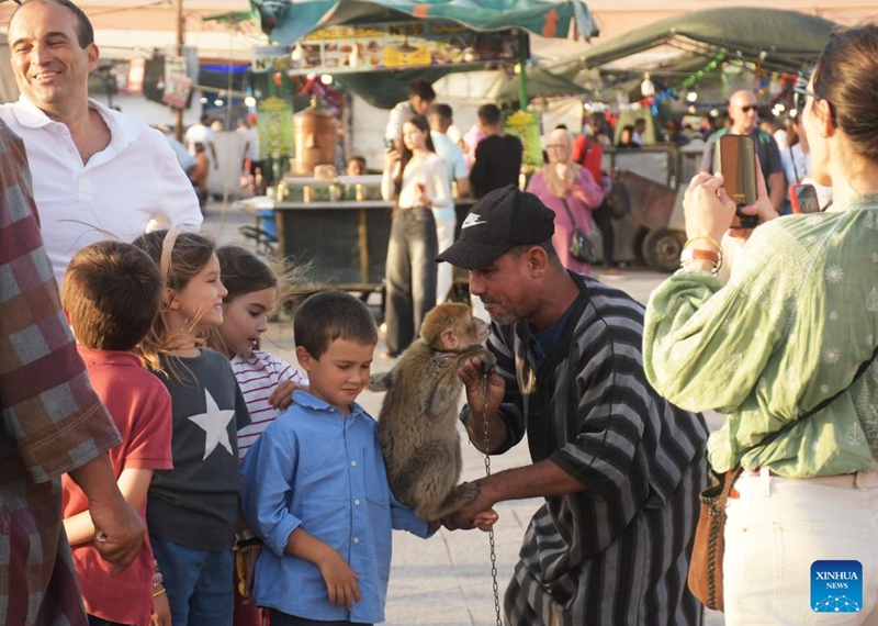 Tourists interact with a monkey at the Jemaa el-Fna square in Marrakech, Morocco, June 5, 2026. Located in the heart of Marrakech, Jemaa el-Fna, a World Heritage Site, is regarded as a Sleepless Square because of the continuous flow of people from morning to night. (Photo by Aissa/Xinhua)