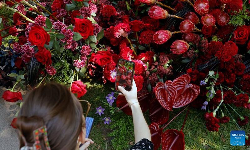 A visitor takes pictures during the opening day of the 4th edition of West Side Flower Fest in Bucharest, Romania, on June 5, 2026. (Photo by Cristian Cristel/Xinhua)