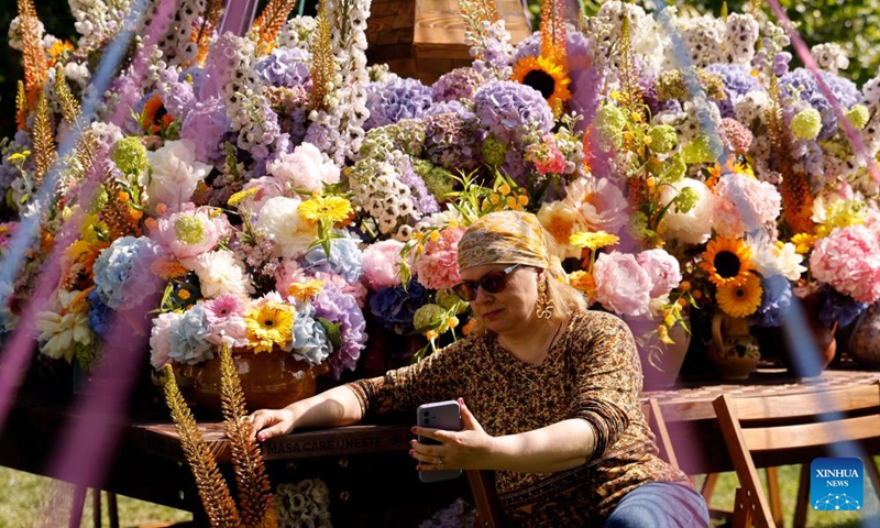 A visitor takes picture during the opening day of the 4th edition of West Side Flower Fest in Bucharest, Romania, on June 5, 2026. (Photo by Cristian Cristel/Xinhua)