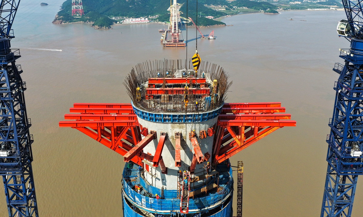 Workers set up a construction platform for the tower's capping at a height of more than 290 meters at the construction site of the Jintang-side main tower of the Xihoumen Highway and Railway Bridge in Zhoushan, East China's Zhejiang Province on June 7, 2026. The main tower has completed the final concrete pouring and entered the critical phase of capping construction. Photo: VCG