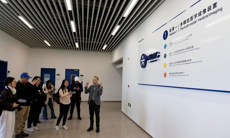 Sun Yujie (R), deputy dean of the College of Future Technology at Peking University, introduces the National Multimode Trans-Scale Biomedical Imaging Center in Beijing, capital of China, March 20, 2025. (Xinhua/Jin Liwang)