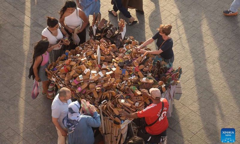 Tourists buy sandals at the Jemaa el-Fna square in Marrakech, Morocco, June 5, 2026. Located in the heart of Marrakech, Jemaa el-Fna, a World Heritage Site, is regarded as a Sleepless Square because of the continuous flow of people from morning to night. (Photo by Aissa/Xinhua)