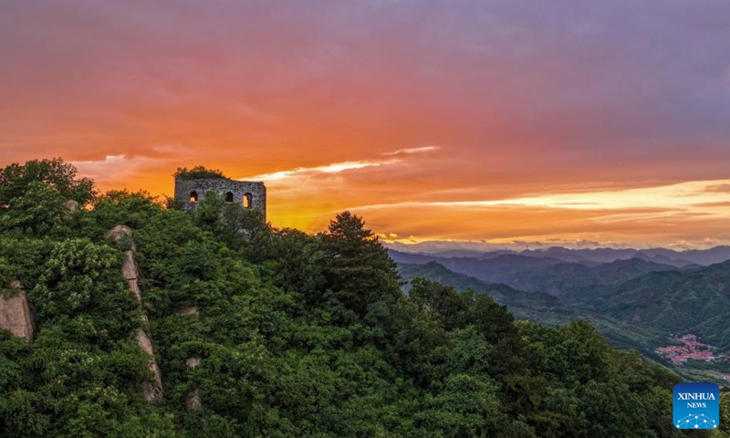An aerial drone photo taken on June 6, 2026 shows the scenery of the Great Wall at sunset in Zunhua City of north China's Hebei Province. (Photo by Liu Mancang/Xinhua)