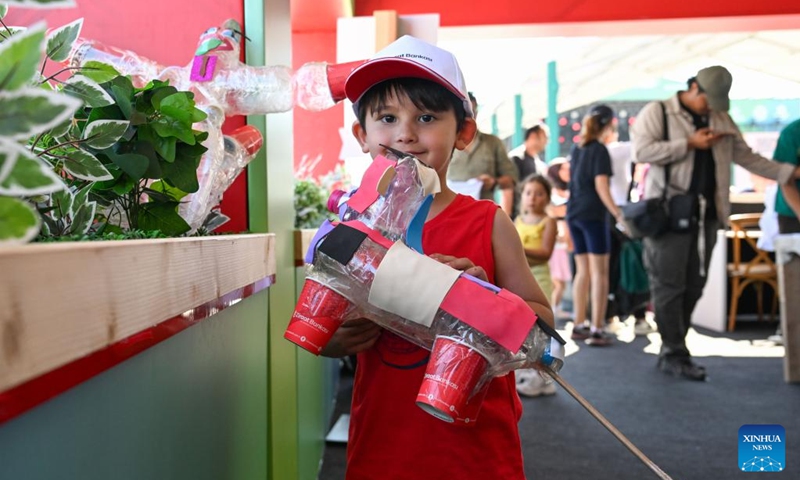 A child displays a handicraft made from recycled bottles and cans at the Zero Waste Festival in Istanbul, Türkiye, on June 6, 2026. The Zero Waste Festival is being held in Istanbul from June 4 to 7. (Xinhua/Liu Lei)