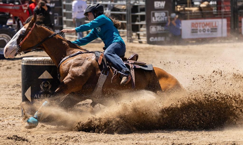 A cowgirl competes during the barrel racing competition at the 2026 RAM Rodeo Tour in Mono, Ontario, Canada, on June 7, 2026. Dozens of competitors participated in this event from June 6 to 7. (Photo by Zou Zheng/Xinhua)