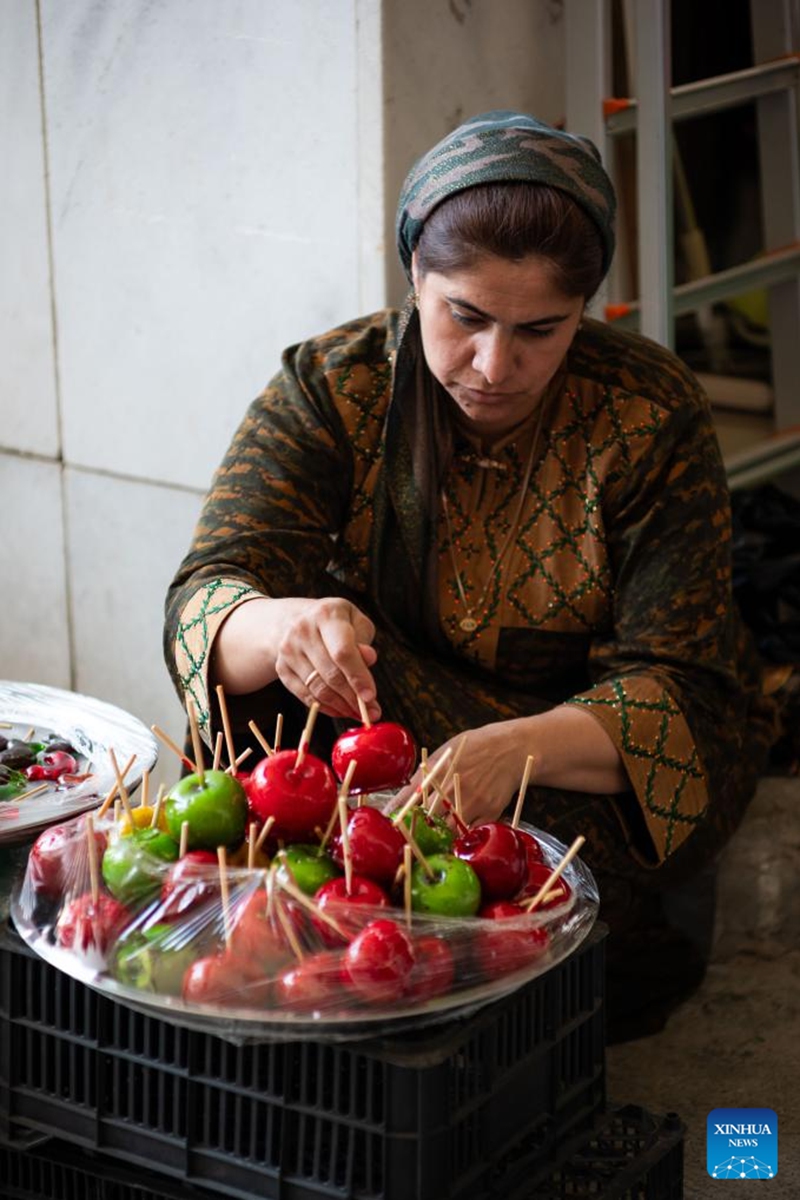 A vendor sells candy apples at the Oriental Bazaar in Ashgabat, Turkmenistan, June 7, 2026. (Photo by Cui Jiaxin/Xinhua)