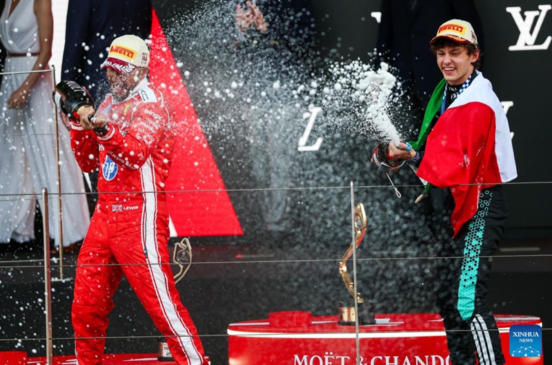 Mercedes' Kimi Antonelli (R) of Italy sprays champagne on the podium with Ferrari's Lewis Hamilton of Britain after the Formula One Monaco Grand Prix at Circuit de Monaco in Monte Carlo, Monaco, June 7, 2026. (Photo by Qian Jun/Xinhua)